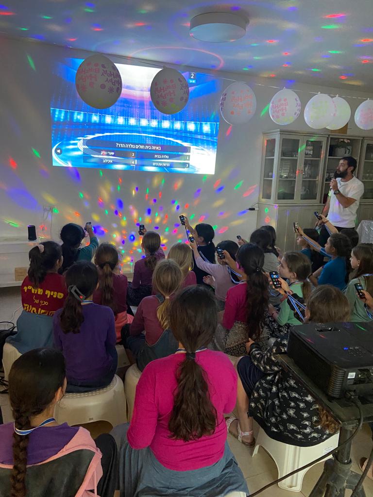קהל משתתף במשחק שלטים דיגיטלי במהלך מסיבת יום הולדת